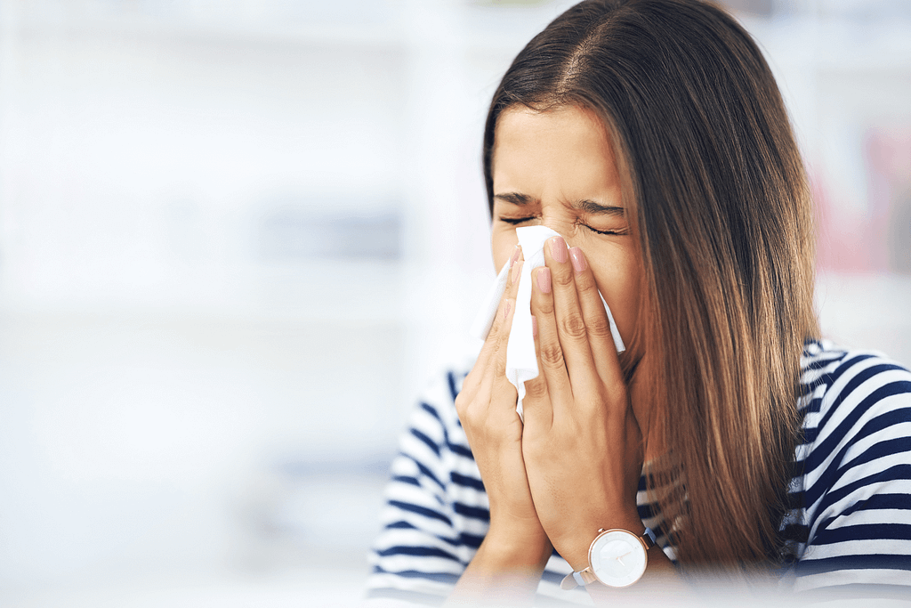 A woman blowing her nose