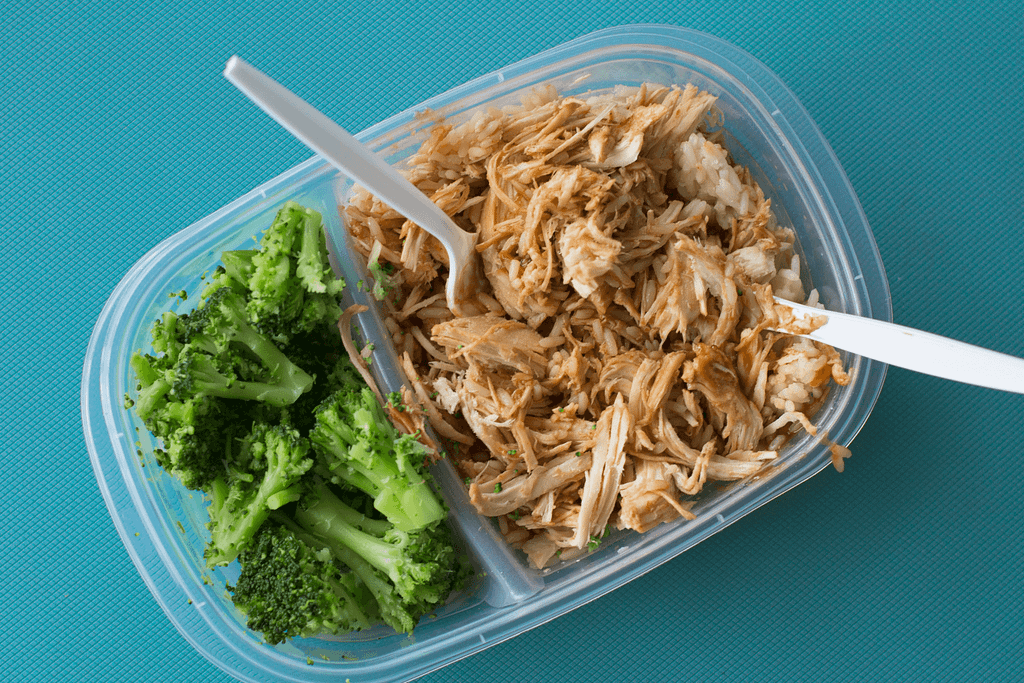 a Tupperware of pulled BBQ chicken and broccoli