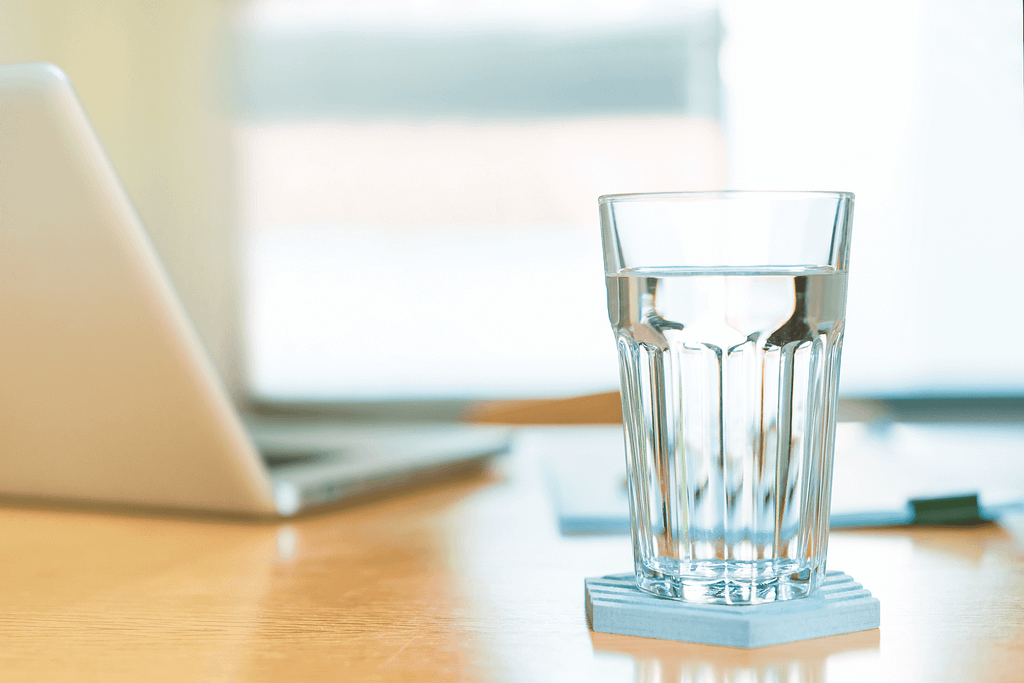 a glass of water on an employee's desk