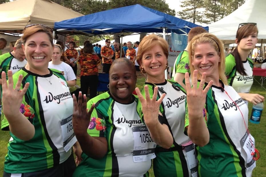 Four women celebrating finishing a relay race together.