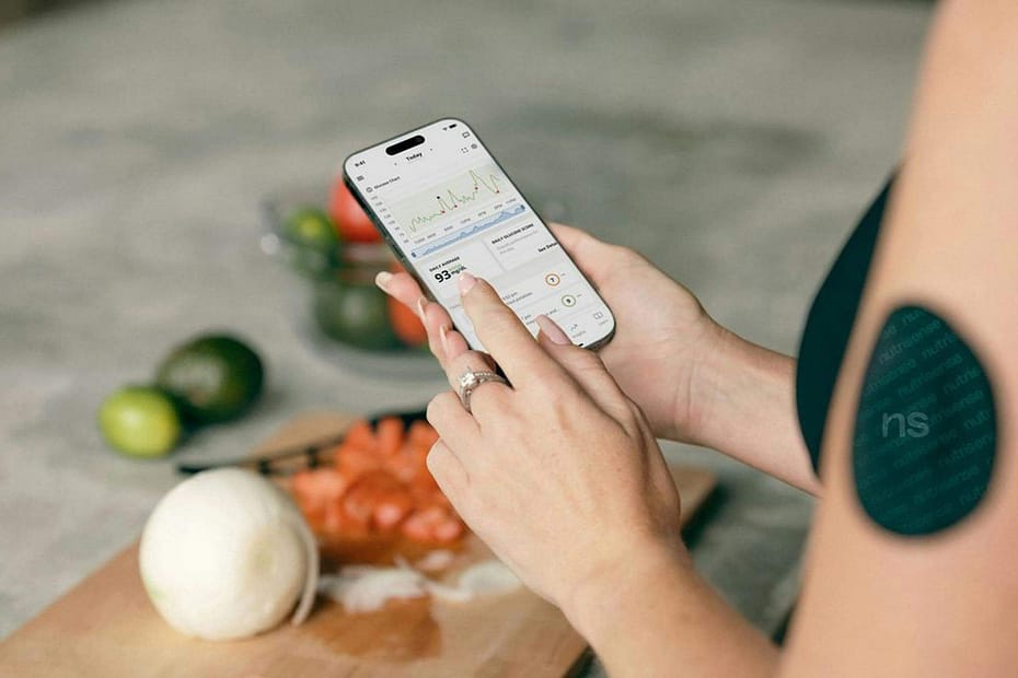 A woman checking her nutritional macros in the wellness app on her phone. Employee wellness apps help users track health data, monitor progress, and support healthier nutrition and wellness habits in real time.