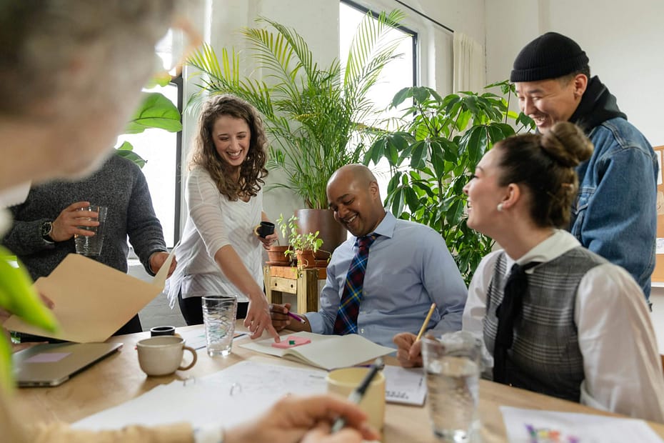 Group of employees gathering in breakroom chatting. Collaborative team-building activities help reduce employee turnover by strengthening workplace relationships, improving communication, increasing employee engagement, and creating a positive, connected workplace culture.